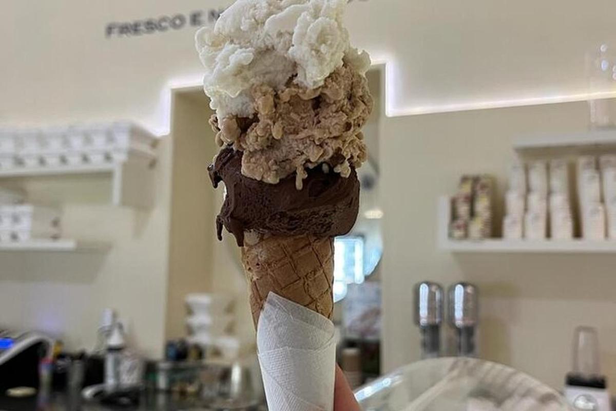 una persona che tiene in mano un cono gelato al cioccolato
