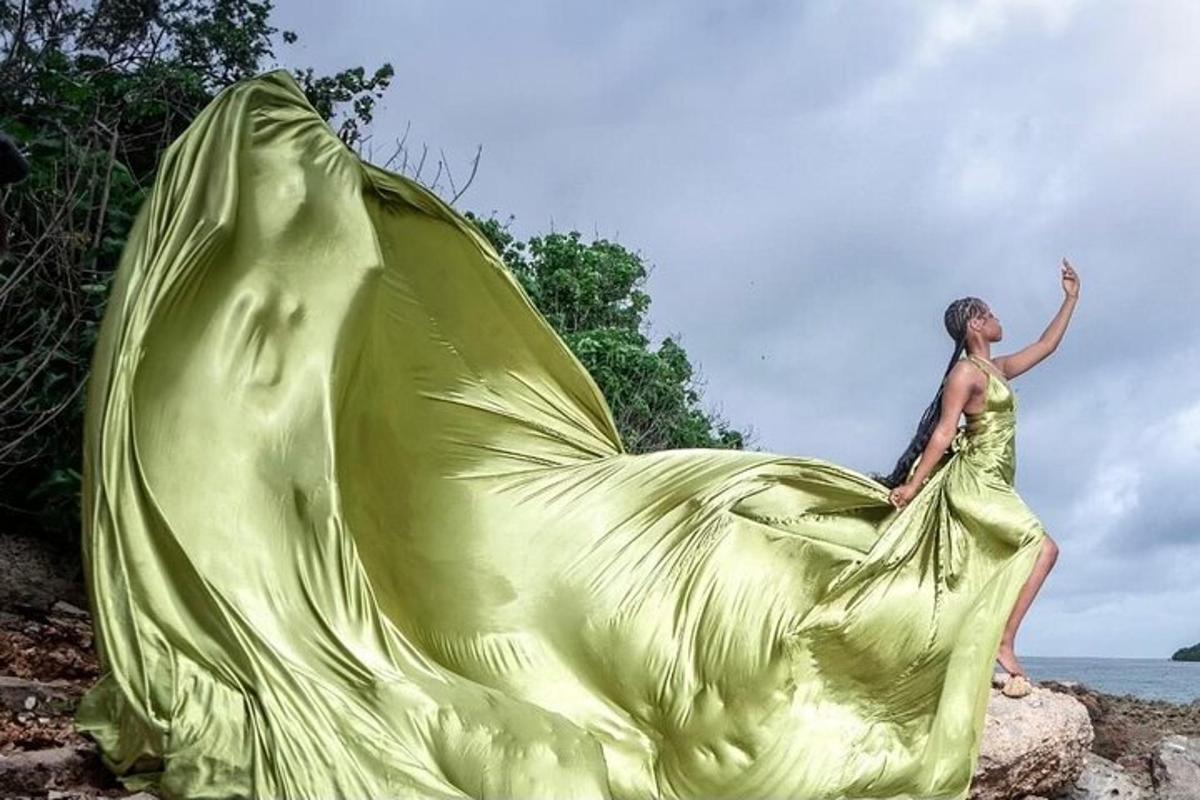 a woman in a green dress sitting on a rock
