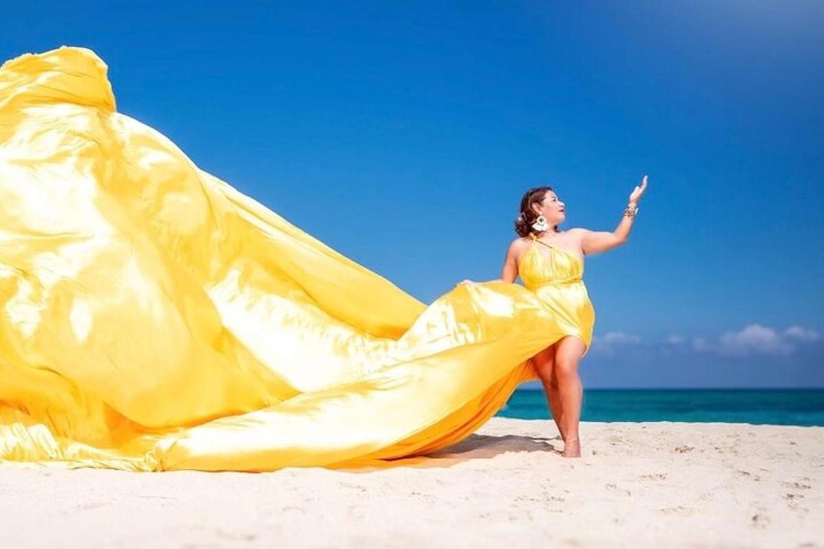 a woman in a yellow dress on a beach
