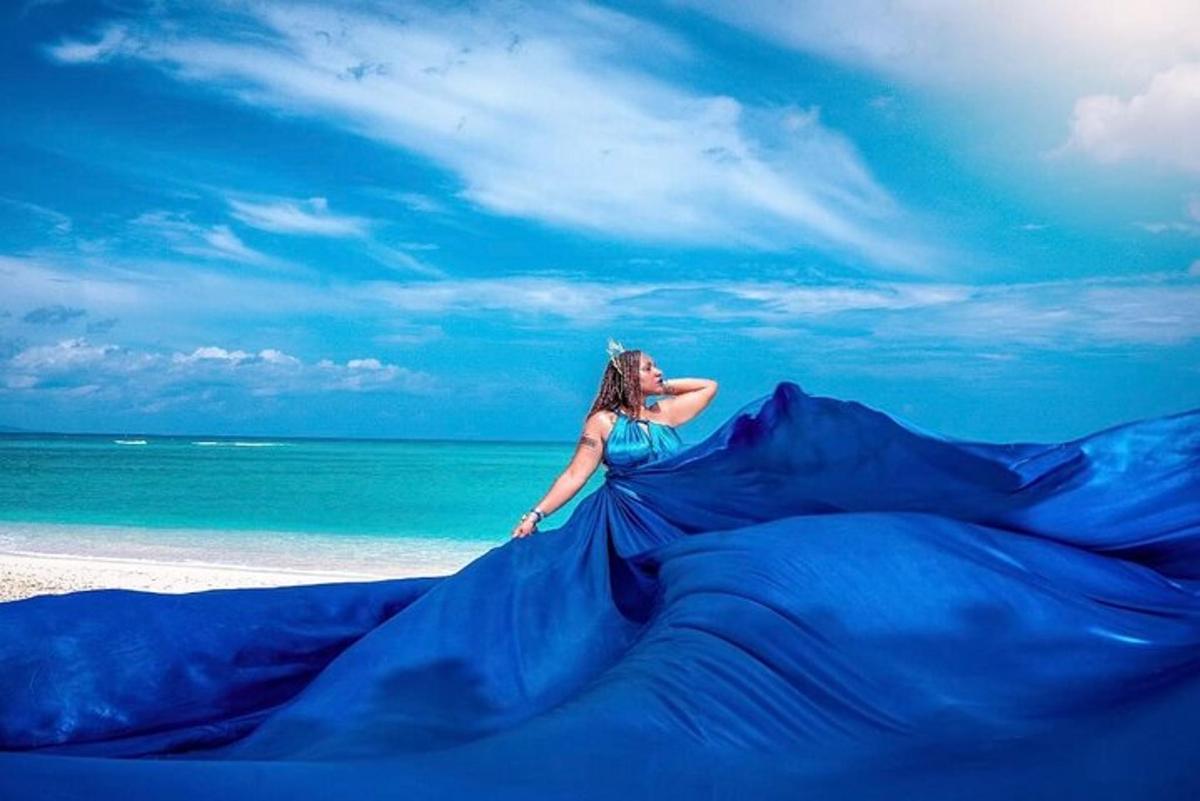 a woman in a blue dress on the beach
