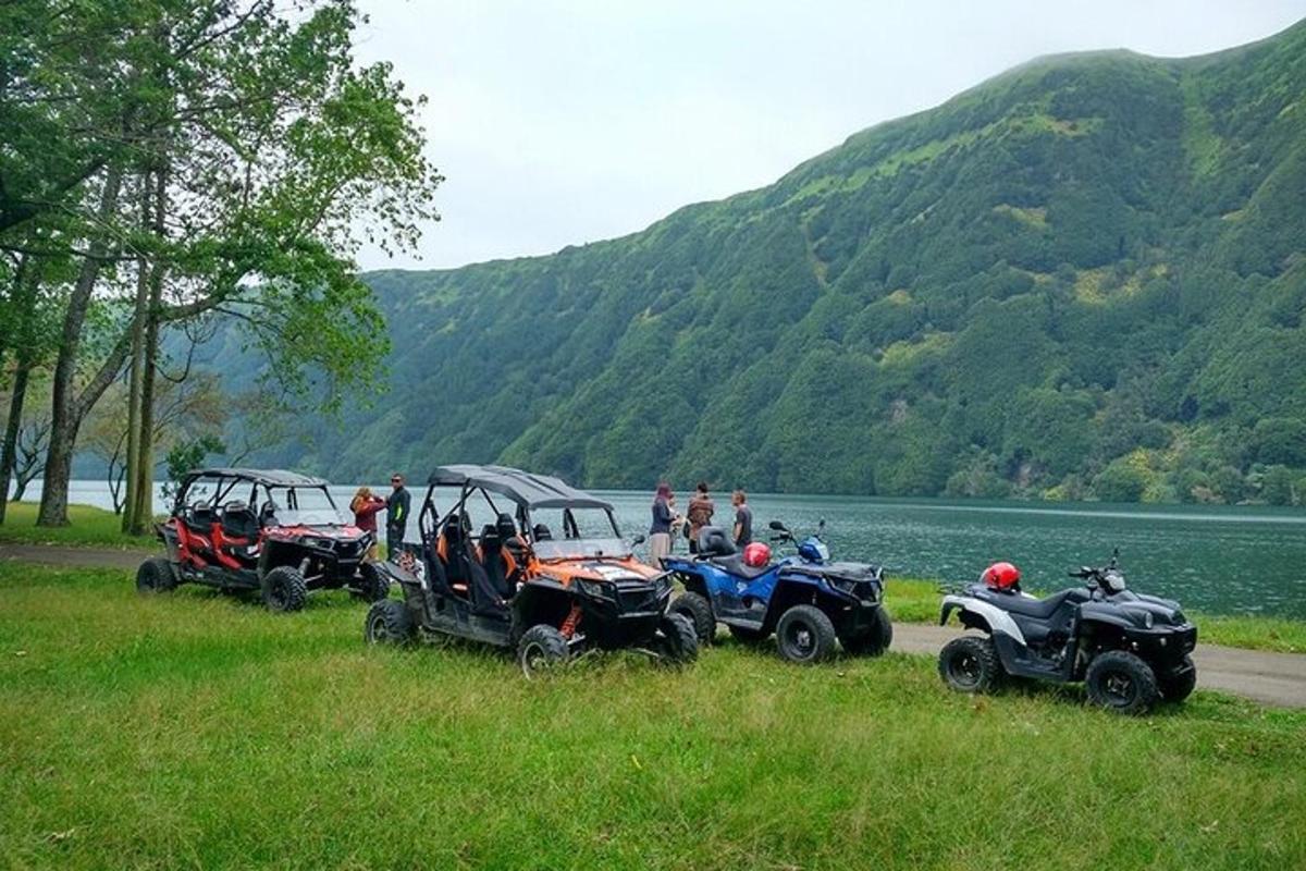 Skupina čtyř čtyřkolek a čtyřkolek a lidí stojících u řeky