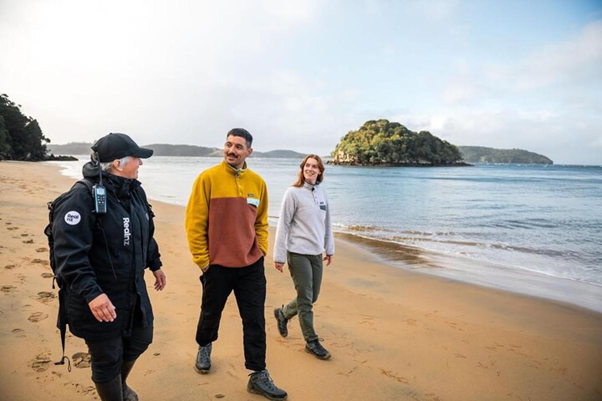 a group of three people walking on the beach