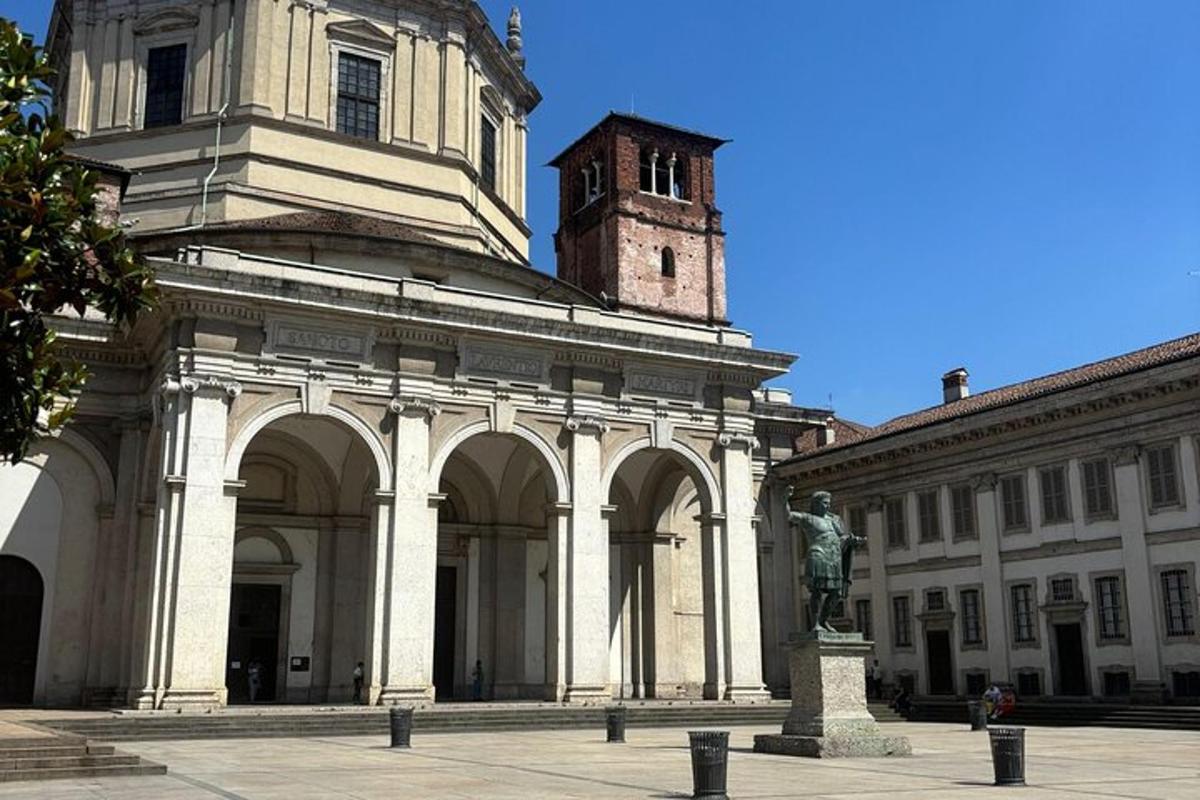 un grande edificio con una torre dell'orologio e una statua