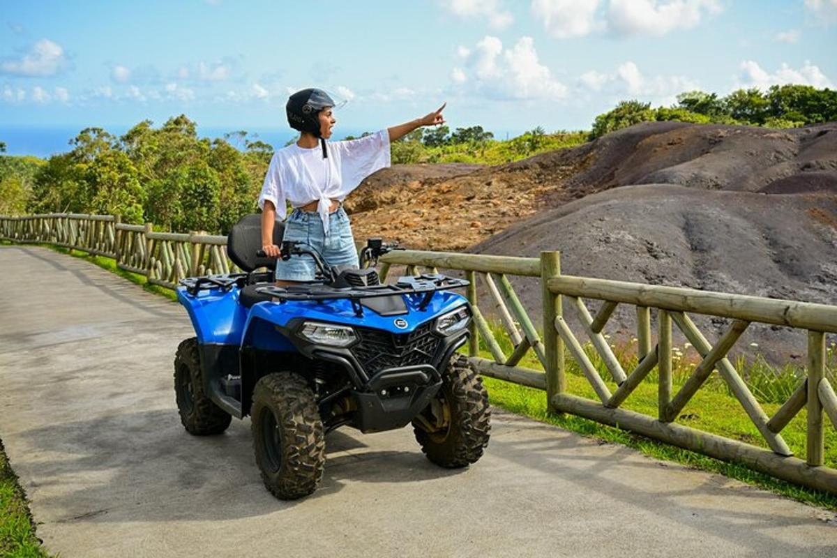 um homem parado ao lado de um quadriciclo em um caminho