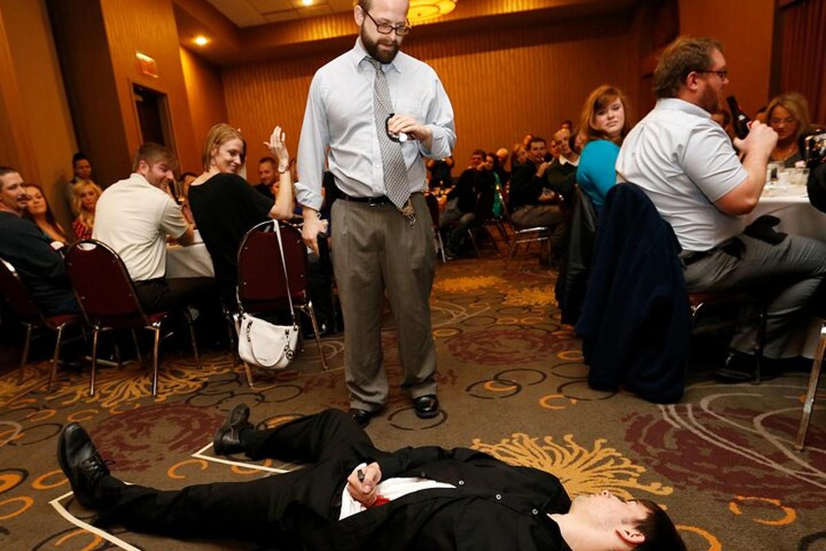 a man laying on the floor in front of a crowd of people