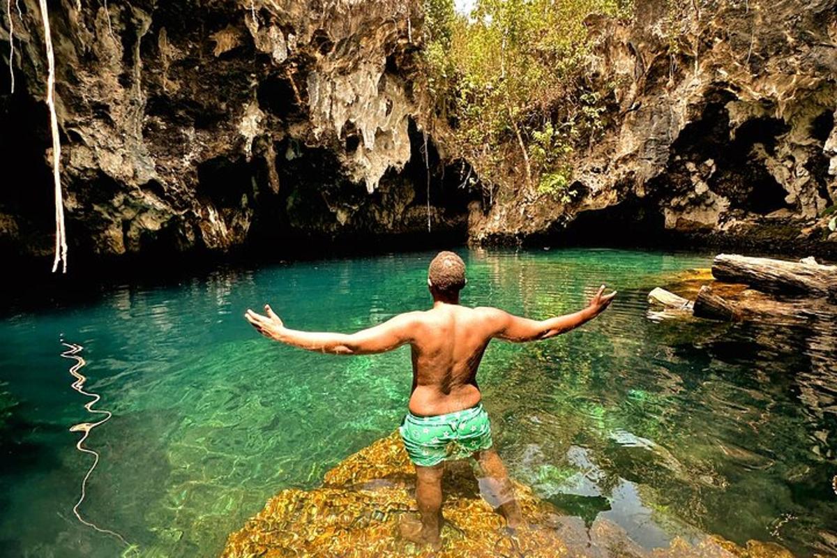 a man standing in the water in a cave