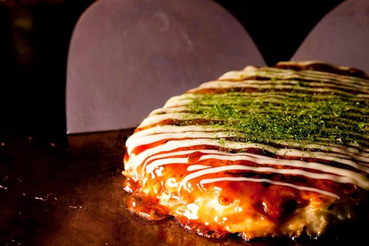 gambar dekat pizza dengan sos dan sayur-sayuran di atasnya