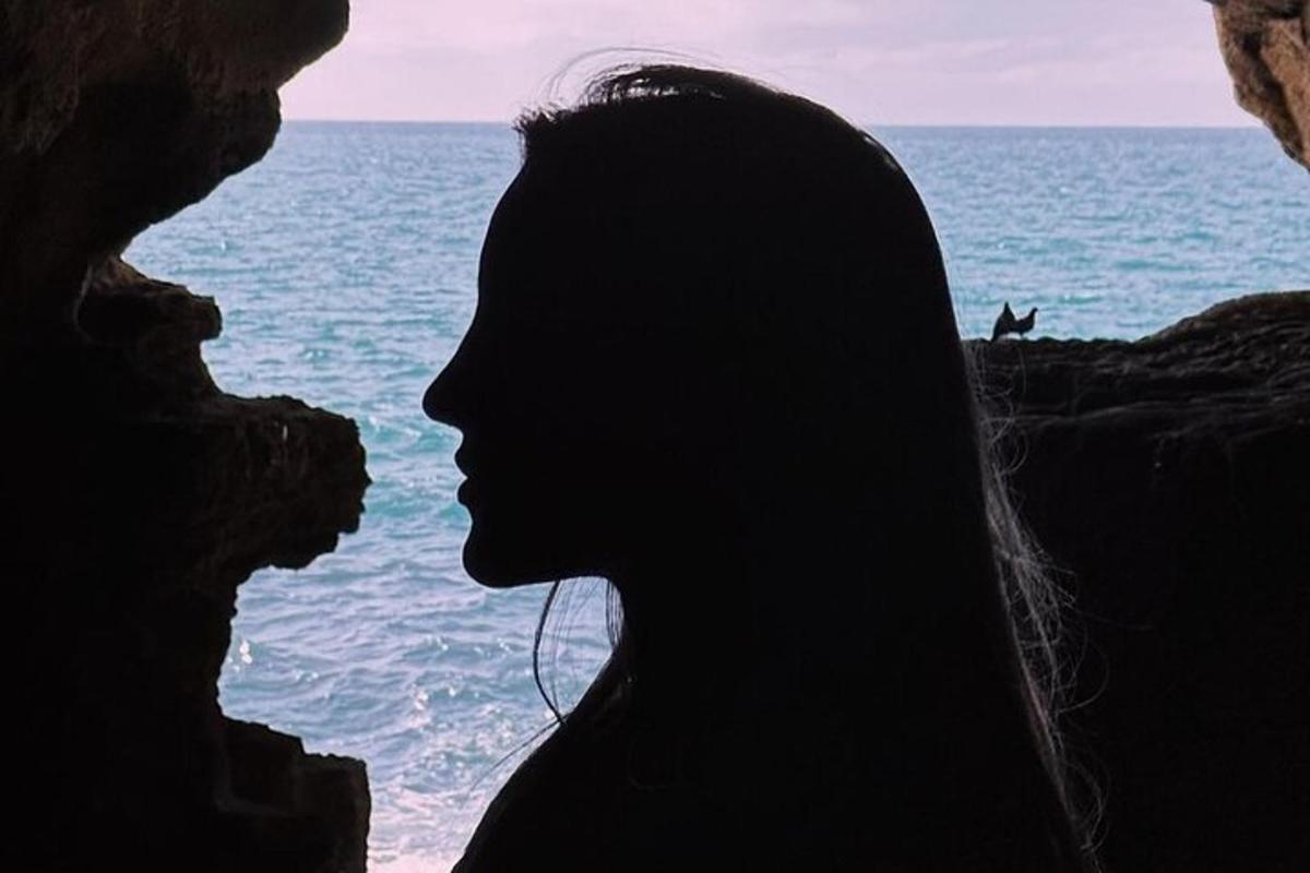 a woman silhouette looking out at the ocean