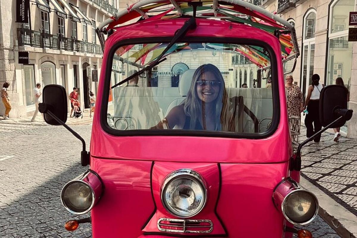 una donna seduta davanti a un'auto rosa