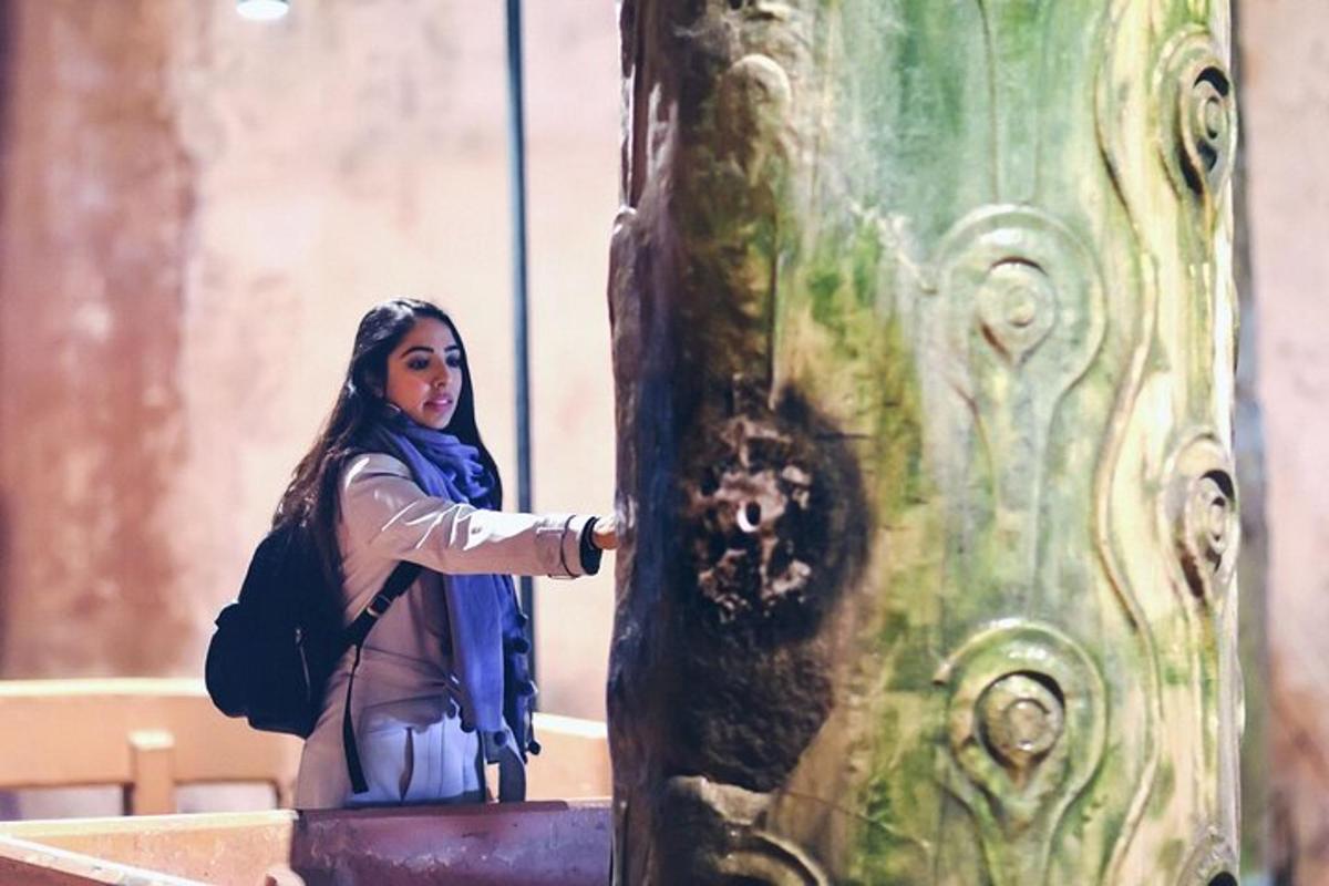 uma mulher está parada ao lado de uma estátua