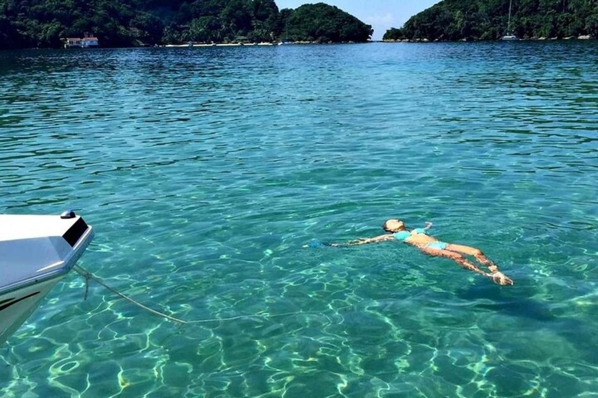 žena plovoucí ve vodě vedle lodi