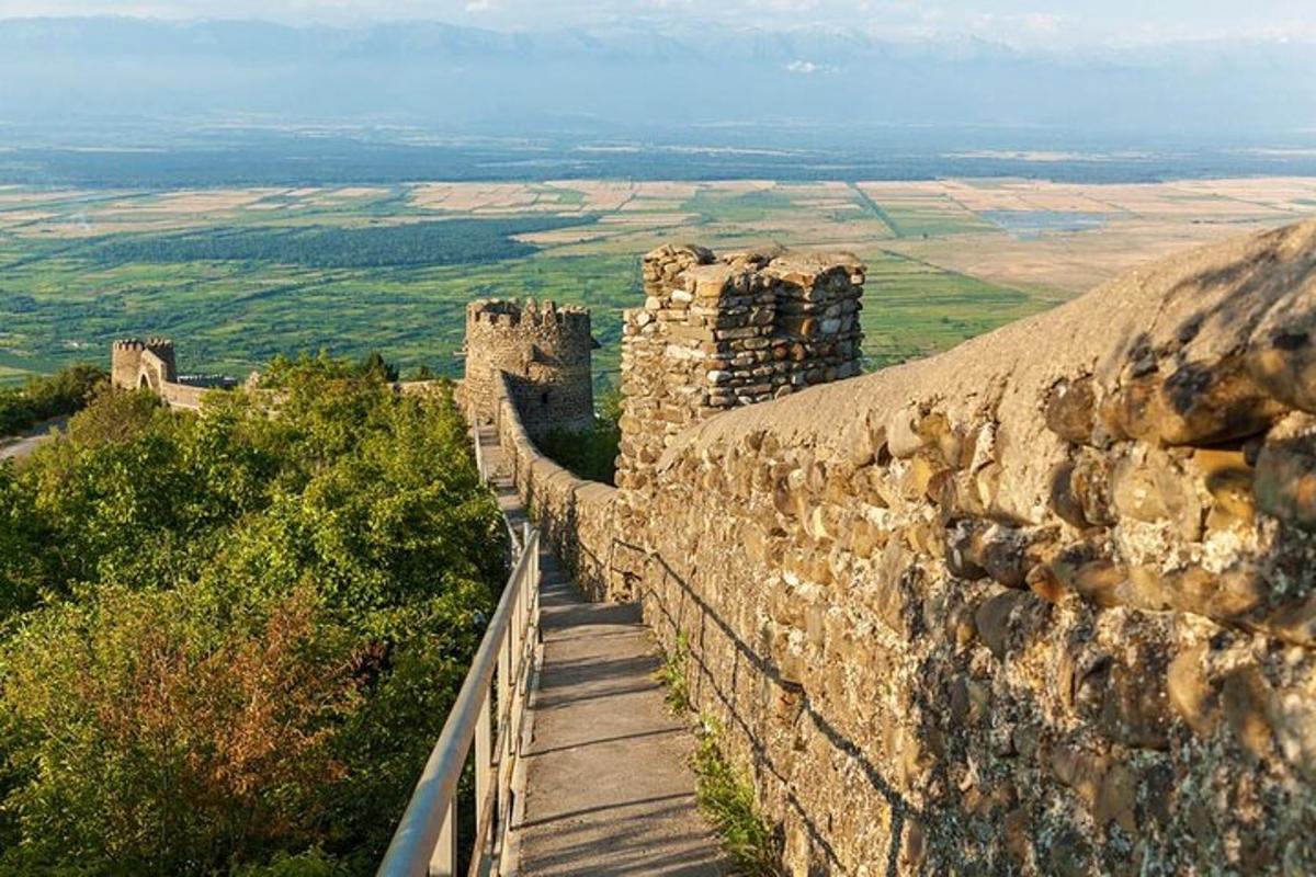 ένας πέτρινος τοίχος με φράχτη από πάνω του