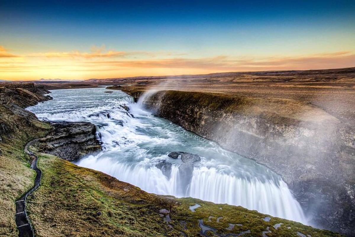 a waterfall on the side of a river