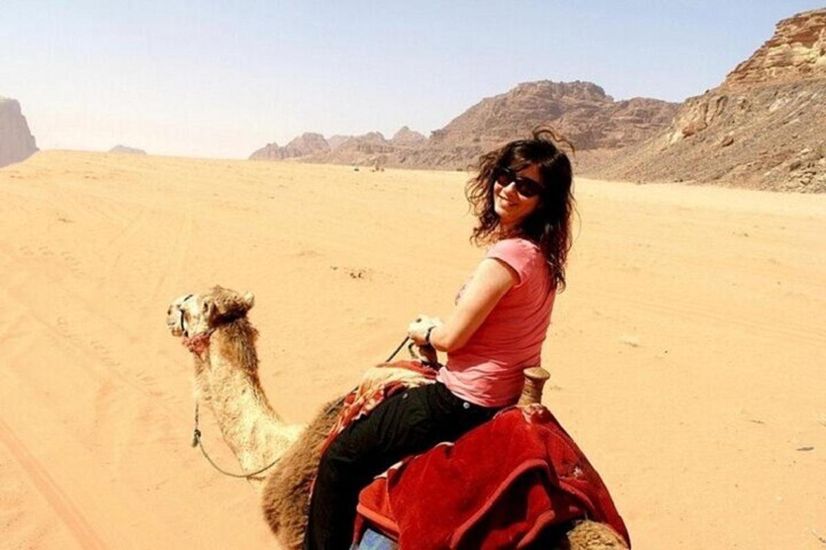 امرأة تركب جملًا في الصحراء