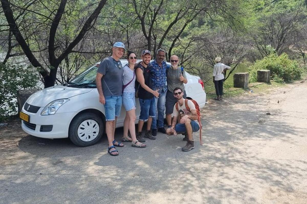 a group of people standing in front of a car