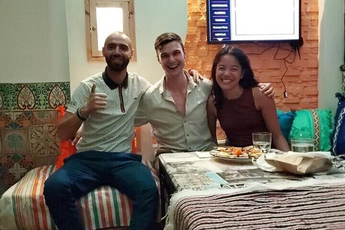 Un hombre y una mujer sentados en una mesa con un plato de comida.
