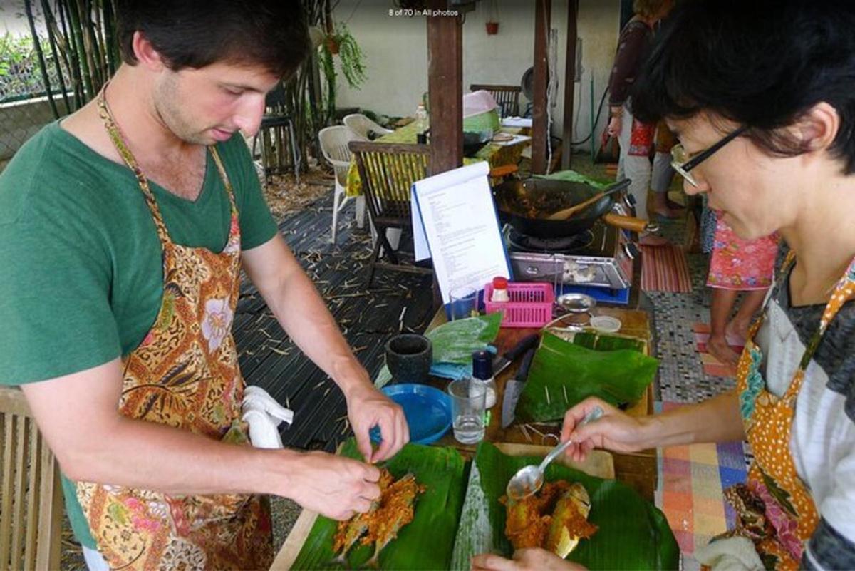 Un hombre y una mujer preparando comida en una mesa.