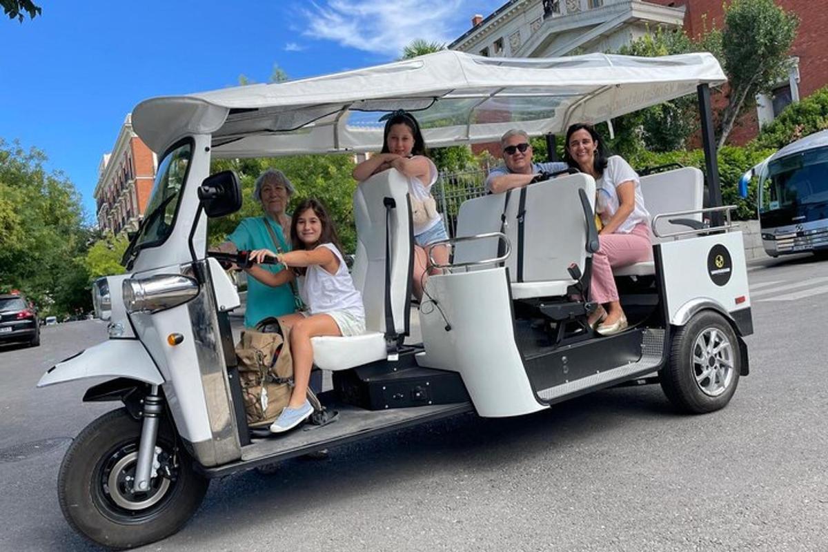 eine Gruppe von Menschen, die in einem Golfwagen fahren