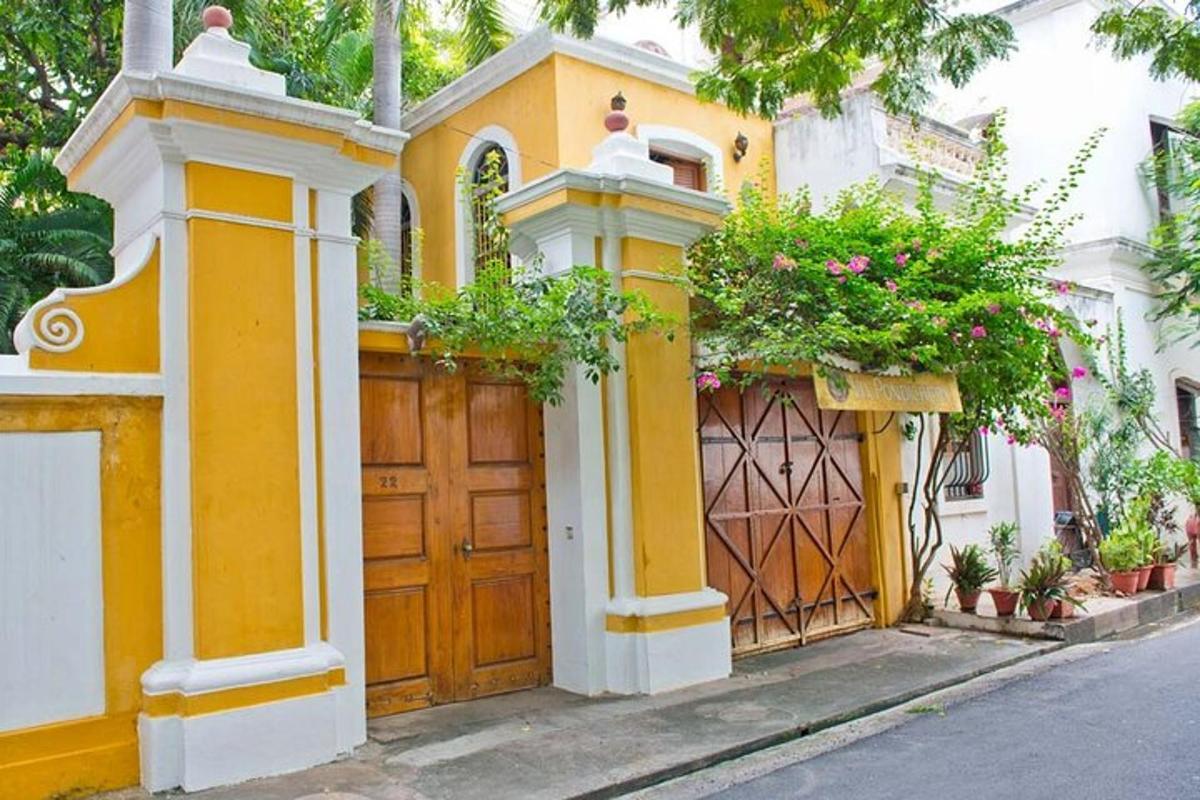 a yellow house with a gate and flowers on it