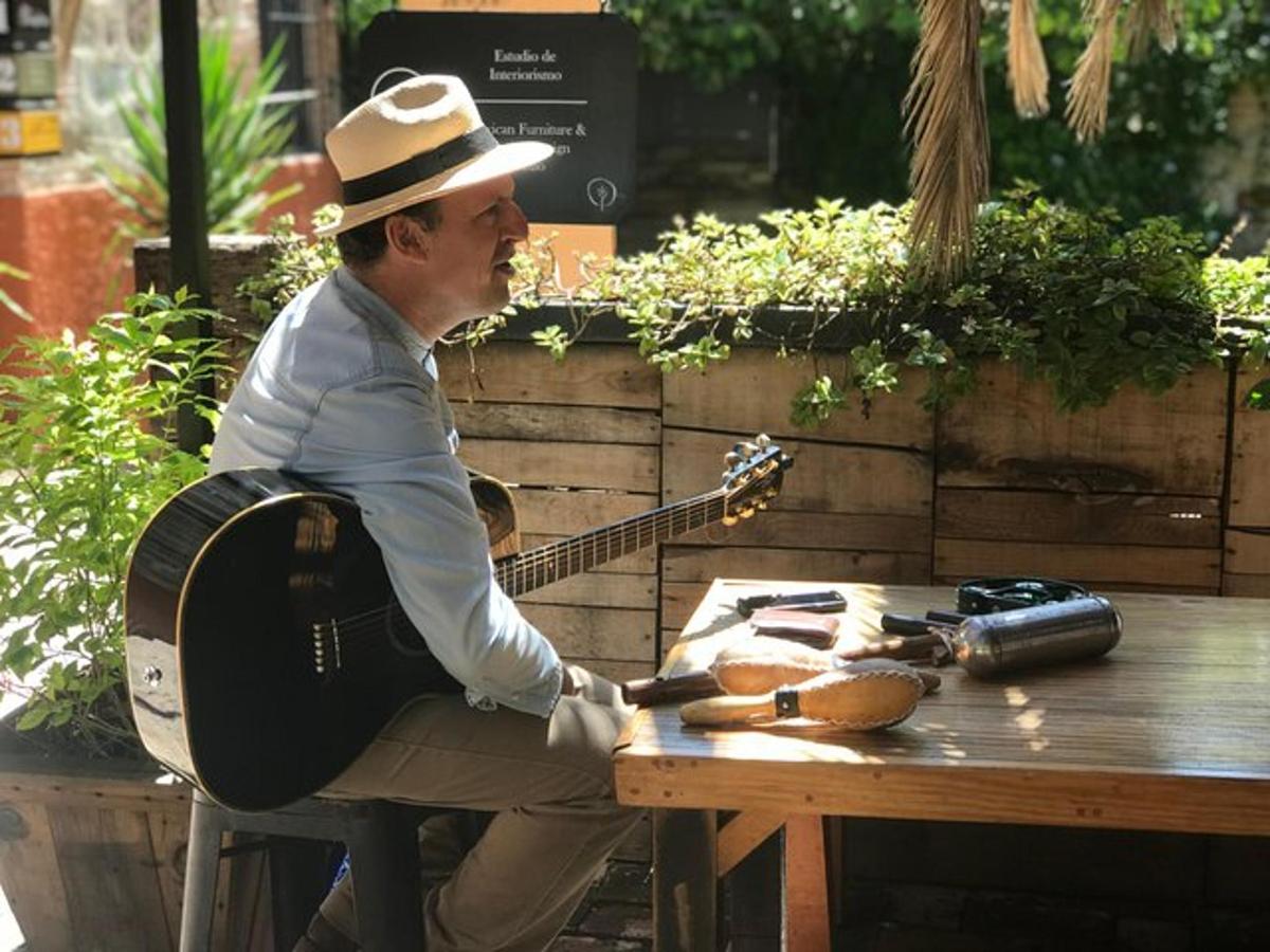 ein Mann, der an einem Tisch sitzt und Gitarre spielt
