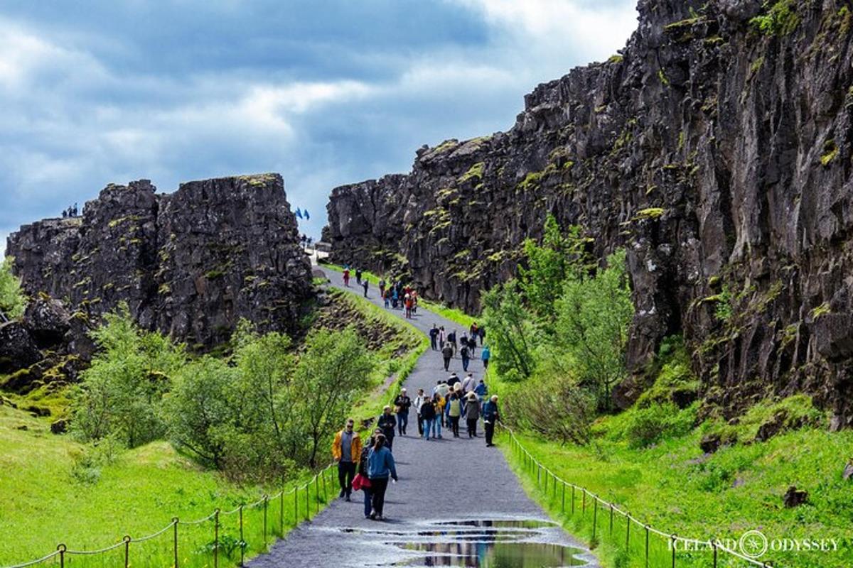 a group of people walking down a road in the mountains