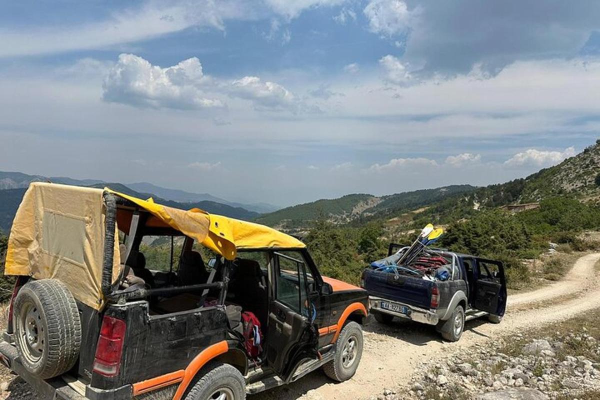 două jeepney-uri parcate pe un drum de pământ