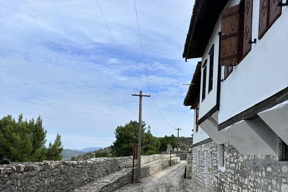 um muro de pedra ao lado de um prédio e um poste