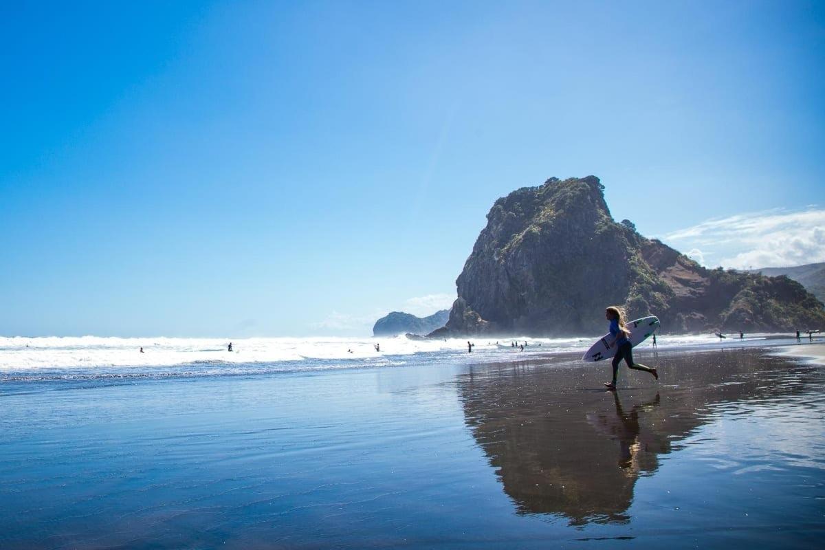 una mujer caminando por la playa con una tabla de surf