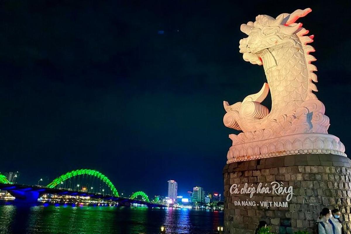 una statua di un drago sulla riva di un fiume di notte