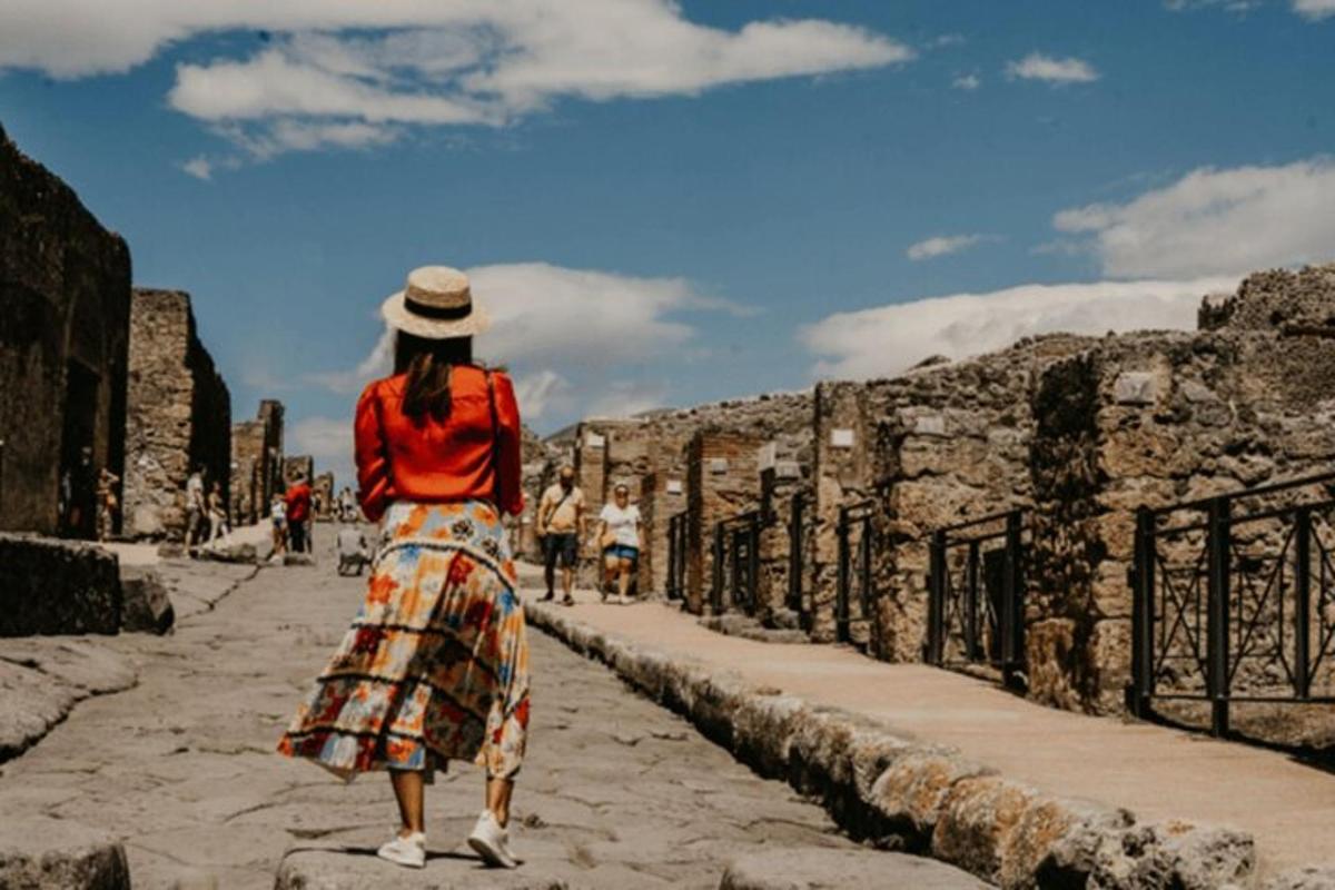 una dona amb camisa i faldilla vermelles caminant pel carrer