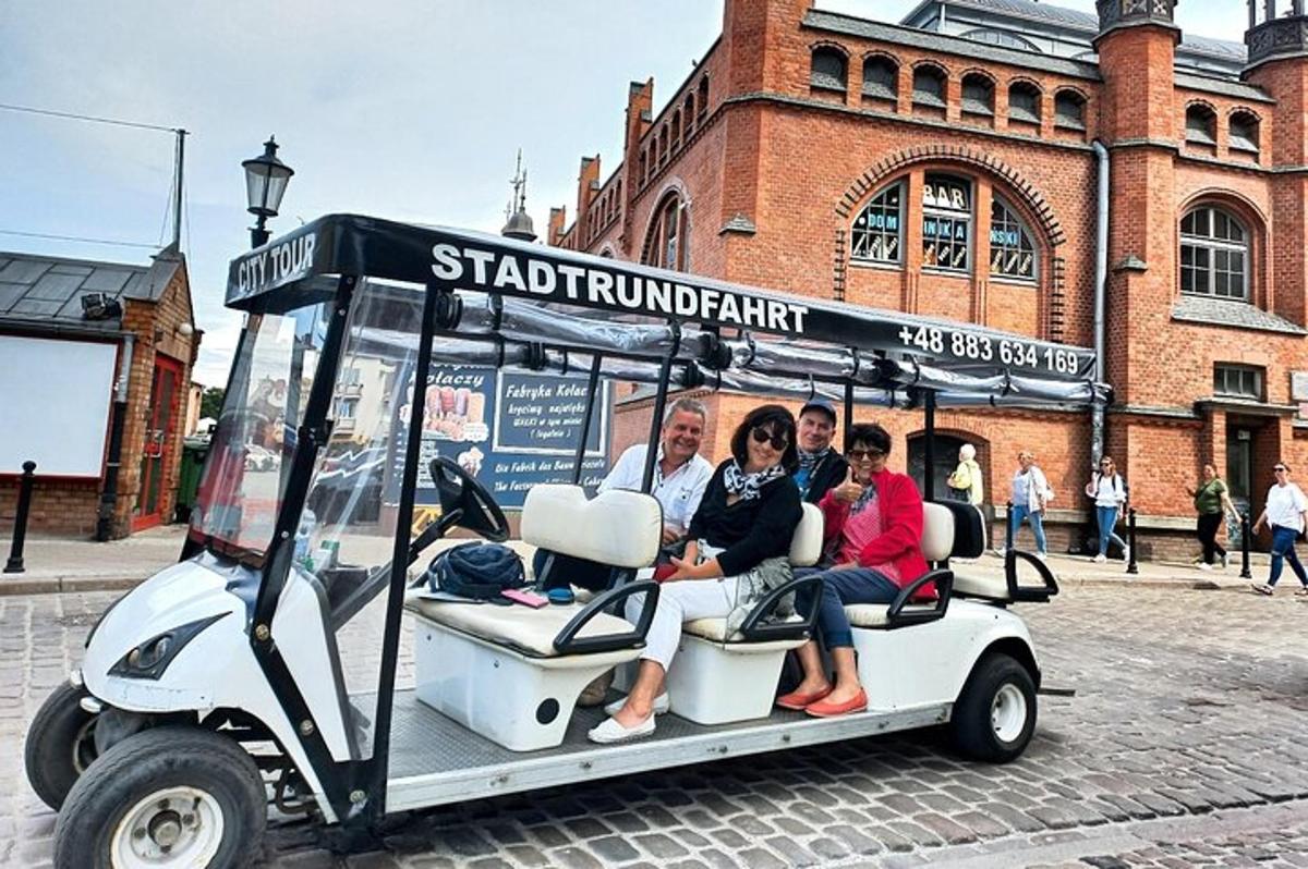 eine Gruppe von Menschen sitzt auf einem Golfwagen