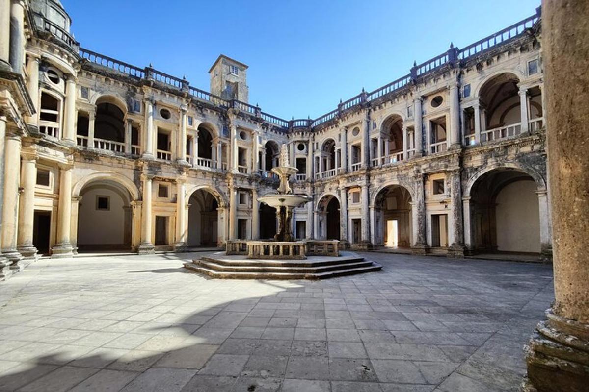 un grande edificio con una fontana in un cortile