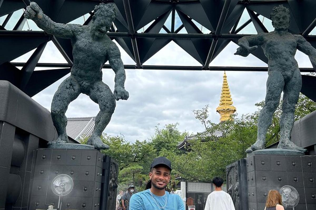 a man is standing in front of two statues