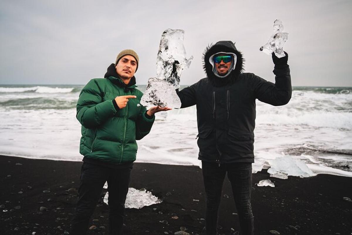 dua pria berdiri di pantai dengan salju di tangan mereka