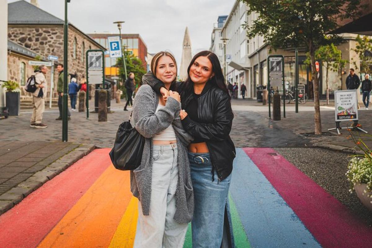 deux femmes debout dans une rue avec un passage piéton arc-en-ciel