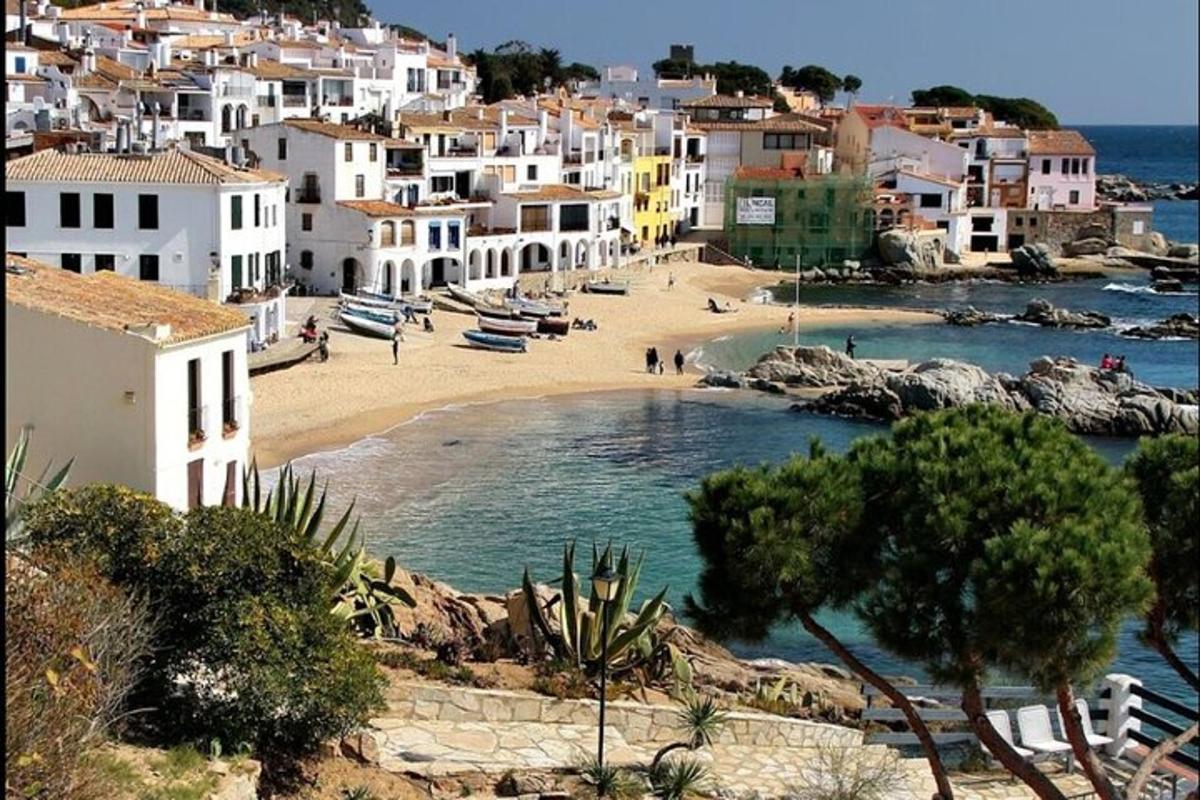 uma praia em uma cidade com casas brancas e água