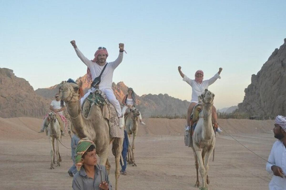 a group of people riding on camels in the desert