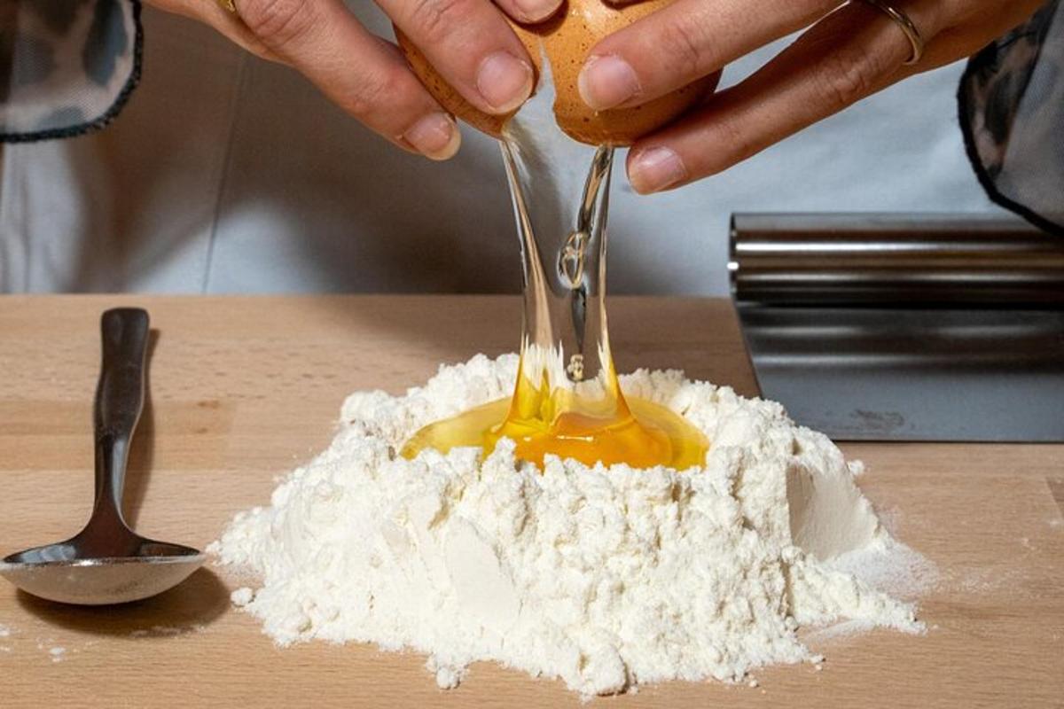 uma pessoa está despejando mostarda em uma pilha de farinha