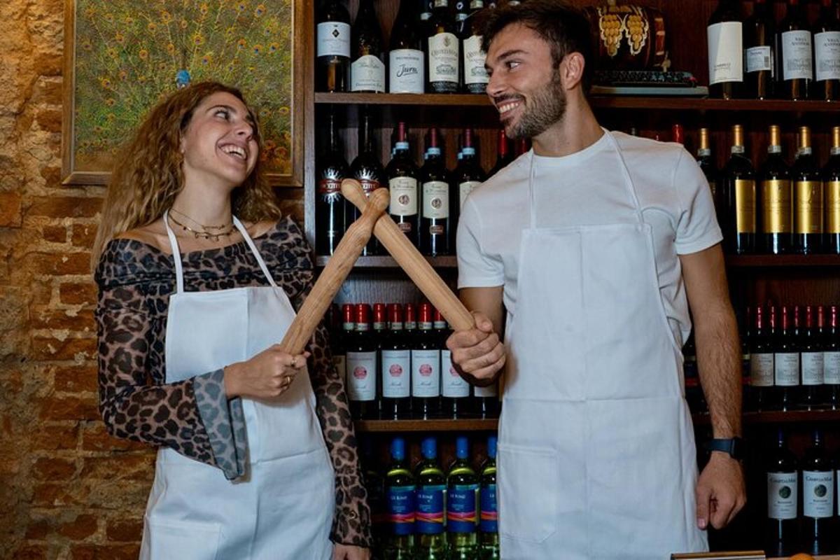un uomo e una donna in piedi accanto a uno scaffale di bottiglie di vino