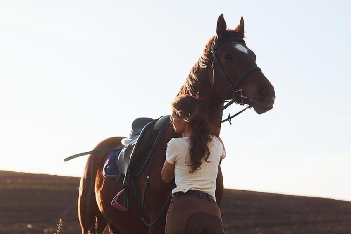 uma mulher está parada ao lado de um cavalo