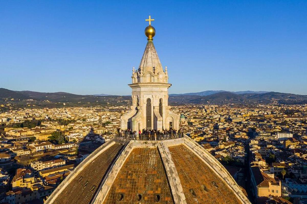uma torre com uma cruz no topo de uma cidade