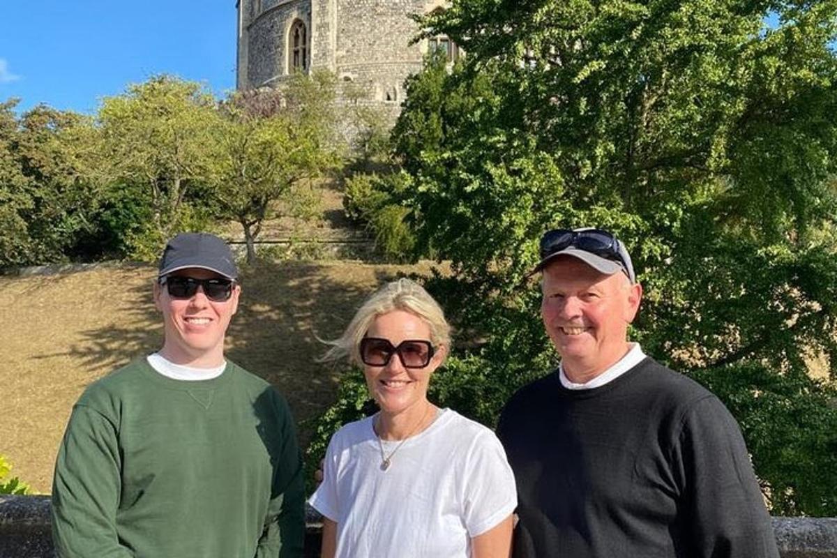 three people posing for a picture in front of a church