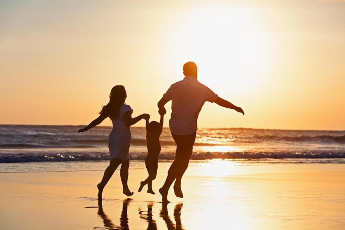 una famiglia che corre sulla spiaggia al tramonto
