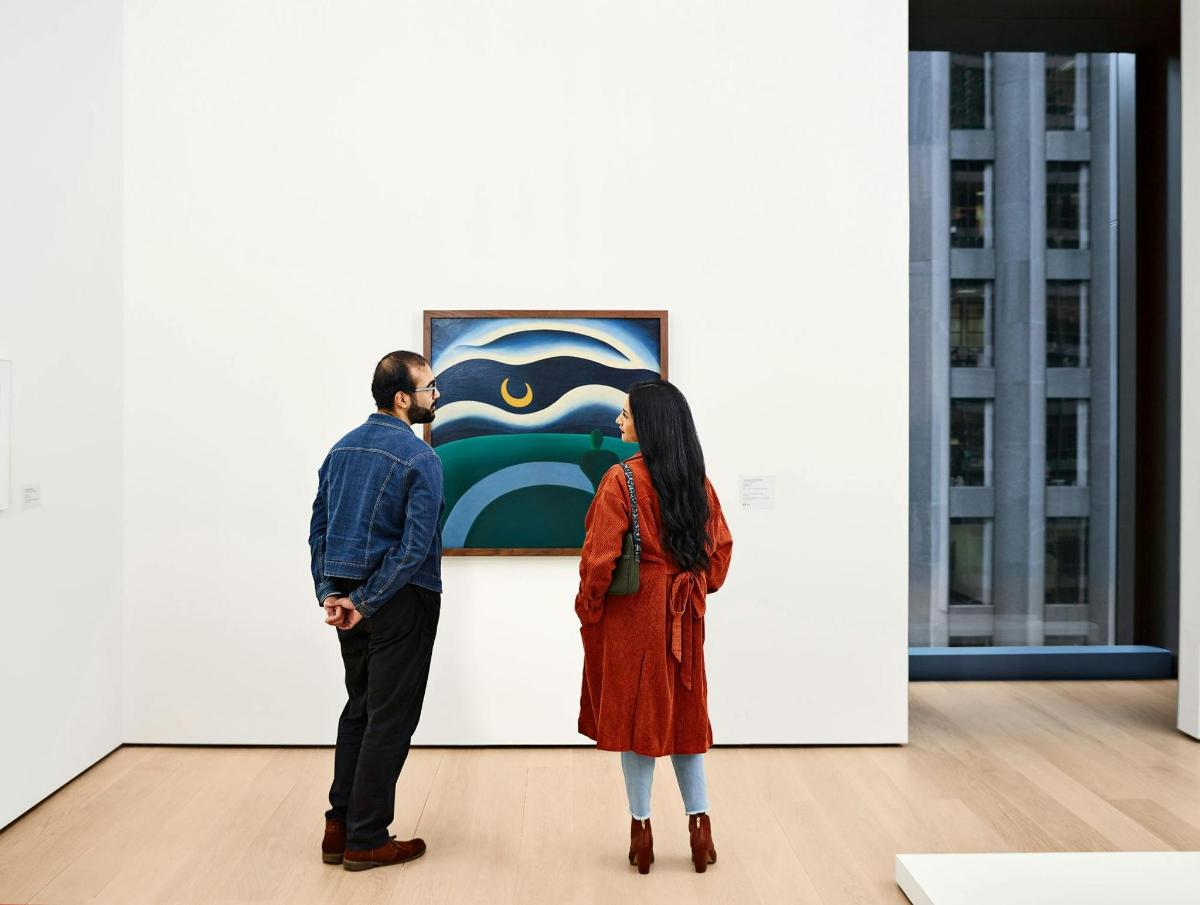 a man and a woman looking at an art exhibit