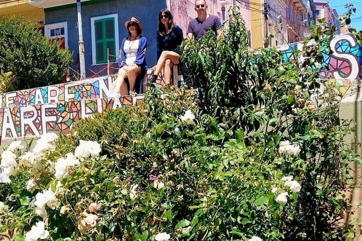 en gruppe mennesker som sitter på et rekkverk med blomster