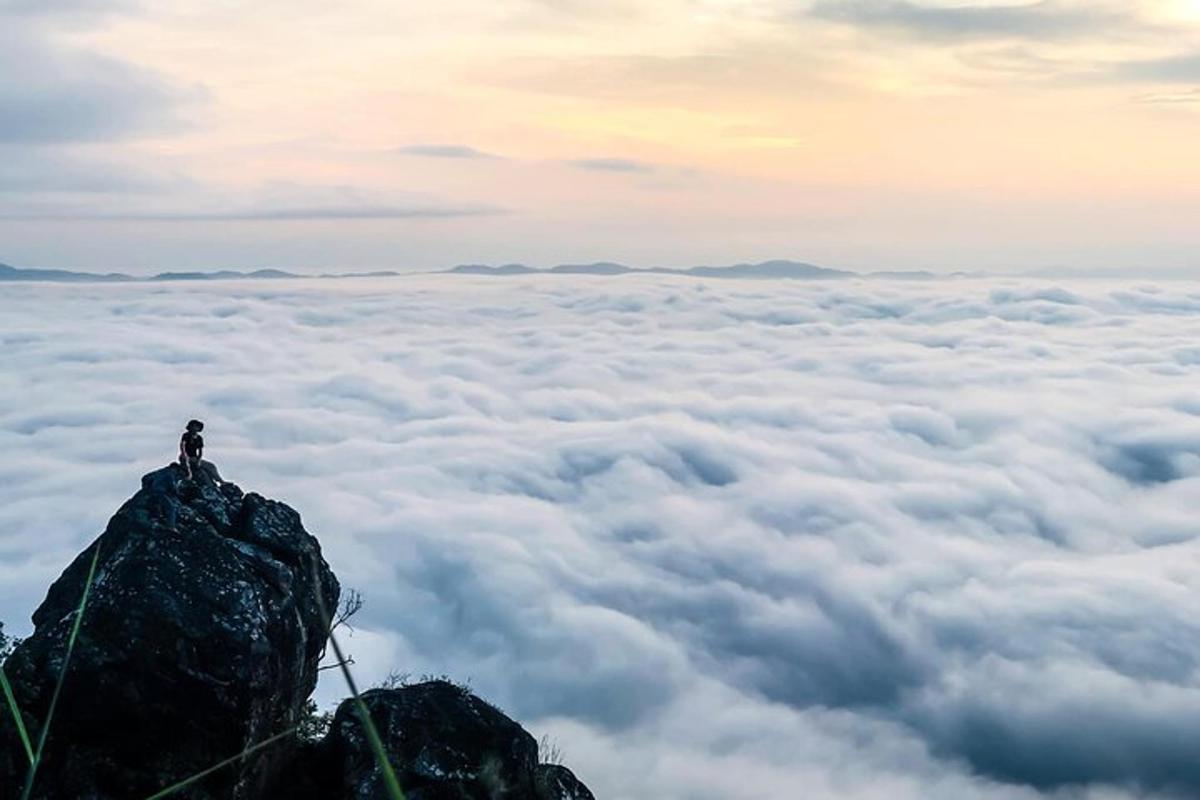 a person standing on top of a mountain above the clouds