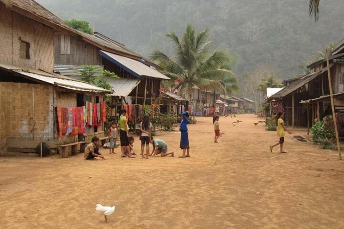 a group of people playing on a dirt road in a village