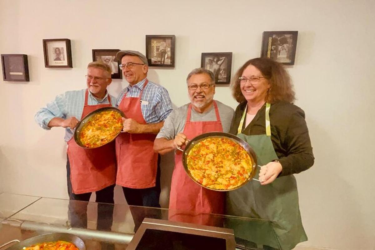 un gruppo di persone che tengono delle pizze in una stanza