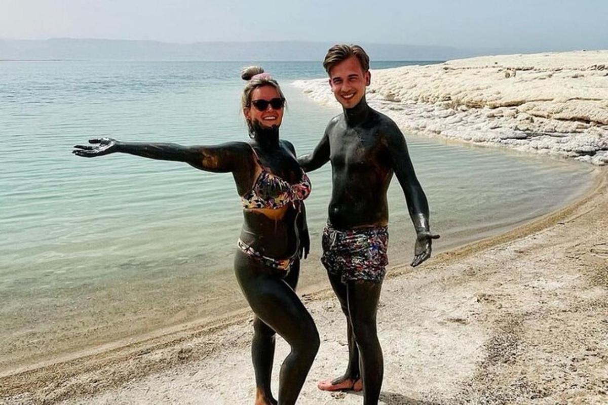 a man and a woman standing on the beach
