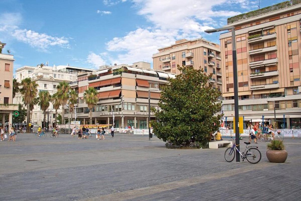 uma praça da cidade com prédios, uma árvore e uma bicicleta